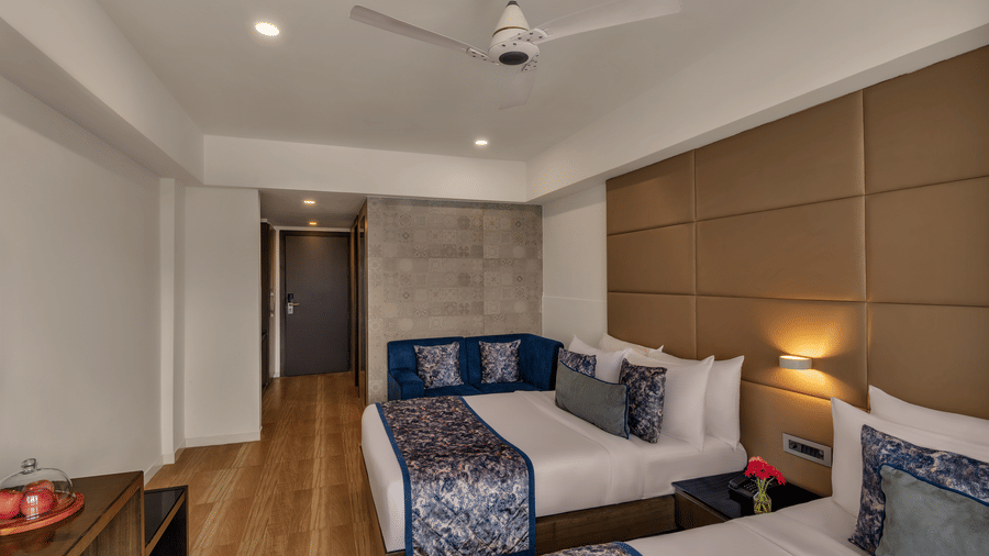 Guest room with twin beds at Voyage Milestone Hotel and Banquet.