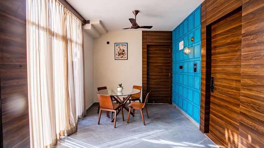 a empty corridor with a table and chairs - Wedlock Greens Hotel Resorts Dhanbad