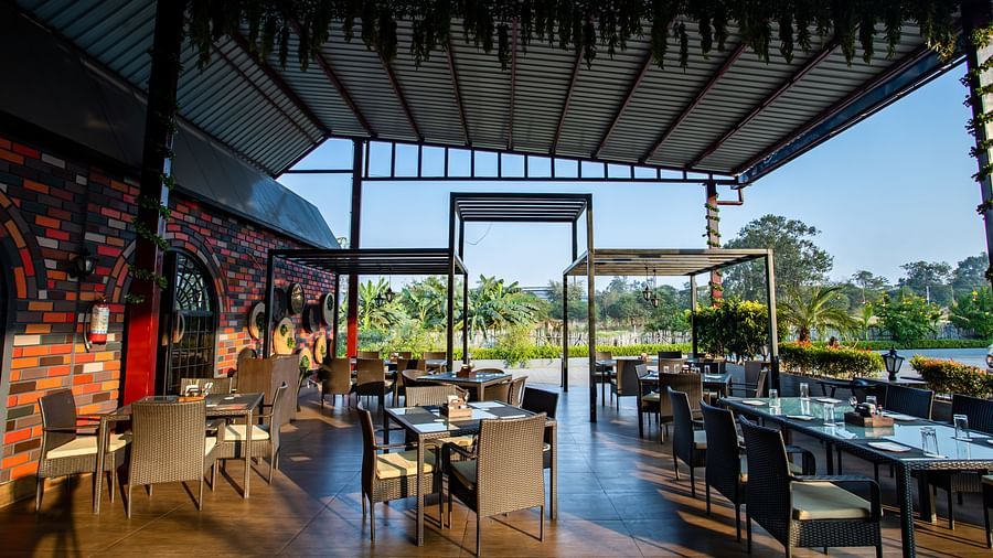 al fresco seating arrangements inside a restaurant - Wedlock Greens Hotel Resorts Dhanbad