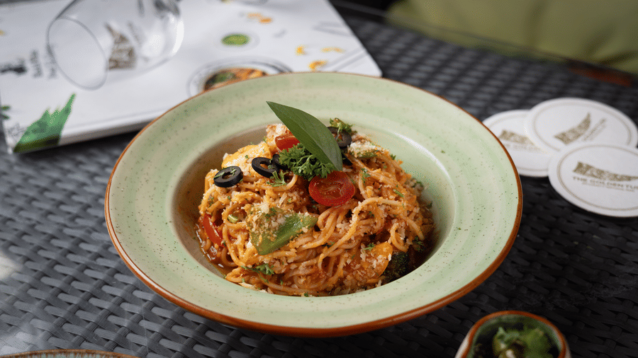 A plate of spaghetti with a green basil leaf garnish on a bowl at The Golden Tusk, Jim Corbett
