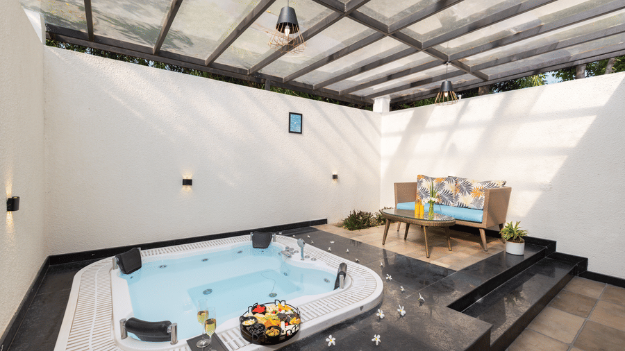 An indoor jacuzzi, set into the floor with towels and items placed on the edge under a covered ceiling.