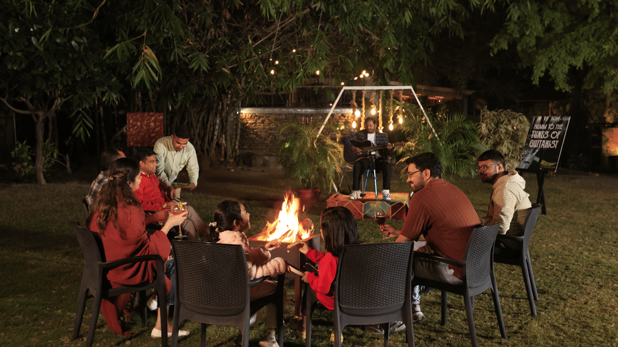 A group of poeple enjoying a bonfire evening outdoors at The Golden Tusk, Jim Corbett.
