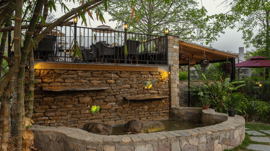 An outdoor patio area with lush greenery at The Golden Tusk, Jim Corbett
