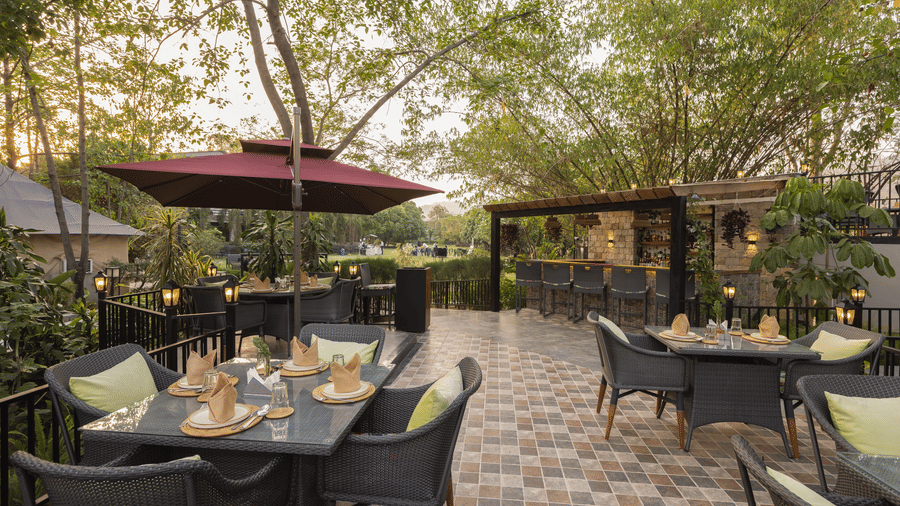  Outdoor restaurant patio with tables, chairs of the restaurant  at The Golden Tusk, Jim Corbett