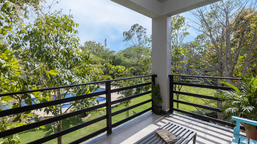 Pool Side Suite balcony with a seating area and lush green views at The Golden Tusk, Jim Corbett