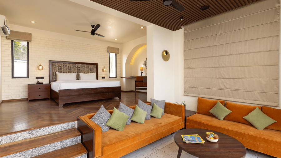 Waterhole Private Pool Villa featuring a split-level design with a bedroom area on an elevated wooden platform and a living area below with orange sofas