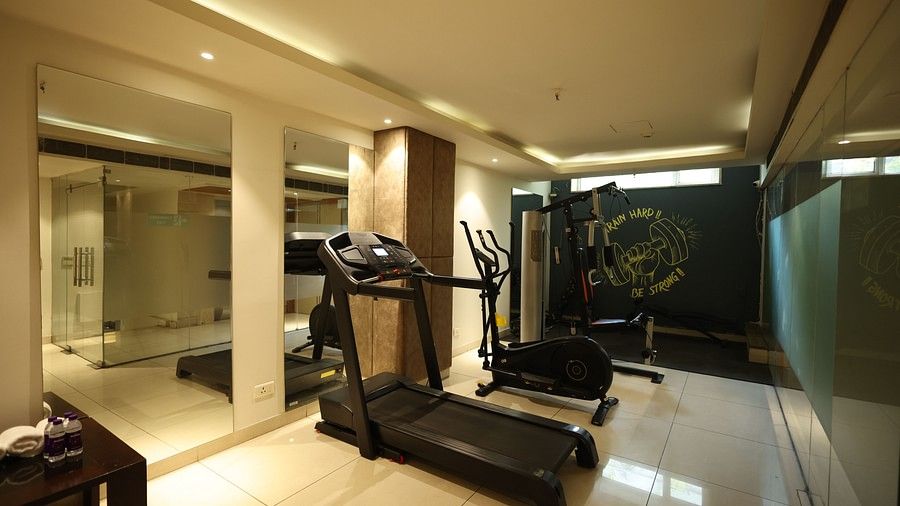 A clean, well-lit hotel gym with a treadmill and other exercise equipment.
