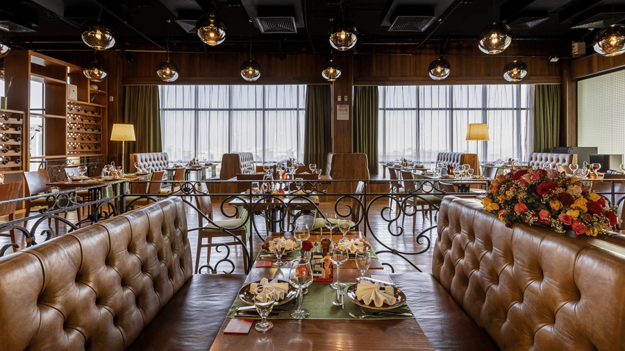 An overview of the sofa seating with a table in the centre having many items on it inside FOGO NO CHÃO restaurant - Ramada by Wyndham Addis, Addis Ababa