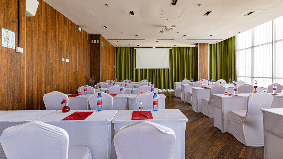 An overview of a meeting room with many tables and chairs in view - Ramada by Wyndham Addis, Addis Ababa.
