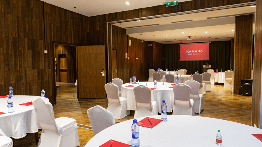 An overview of a meeting room with many round tables and chairs in view - Ramada by Wyndham Addis, Addis Ababa.