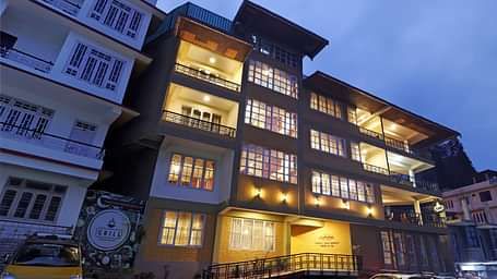 A low-high angle of a well-lit facade of Summit Newa Regency & Spa, Pelling