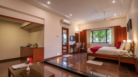 A wide view of a studio-style room showing a small kitchenette area leading into the bedroom - Jenneys Residency, Coimbatore