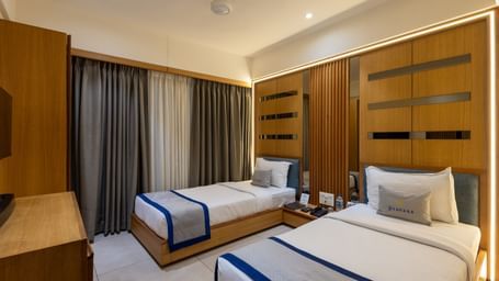 Side view of twin beds in the Superior Room of Pravasa Stay Vijay Nagar, Indore.