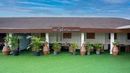 Shot of the exterior of spice lounge with a green law at the entrance |  The Grand Legacy Resort and Spa