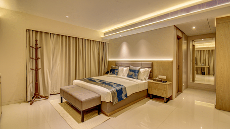 A hotel room with a bed, a bench, and a view of the bathroom - The SSK Solitaire Boutique Hotel & Spa, Gangapur Road - Nashik