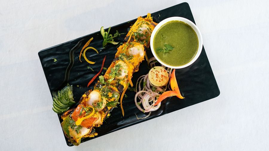 image of a paneer tikka platter served on a black rectangular dish with coriander chutney