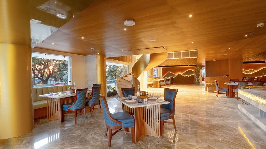 Image of a dining space with seating area and wooden ceiling at Auradoon, Dehradun.