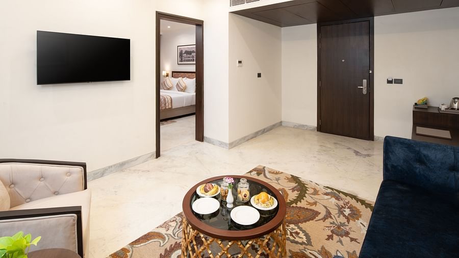 An image of a seating area with sofa set, centre table, flat TV screen and a photo frame hanged on the wall -  Brij Eternity, Vrindavan