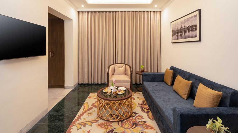 An image of a seating area with sofa set, centre table, flat TV screen and a photo frame hanged on the wall -  Brij Eternity, Vrindavan