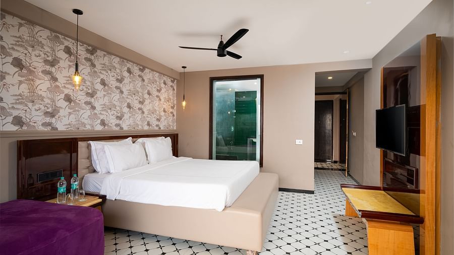 A close-up of a stylishly designed bed and cosy seating area, offering a relaxing atmosphere at Crescent Resort, Goa.