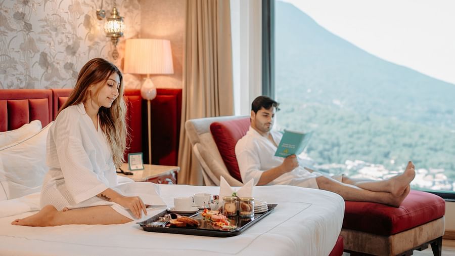 A couple enjoying in-room dining while relaxing on the furniture at Crescent Spa & Resort, Indore
