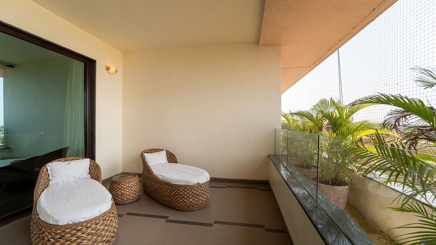 Executive Room balcony boasts cushioned seating with pillows and decorative plants on the walls at Crescent Spa & Resort, Indore