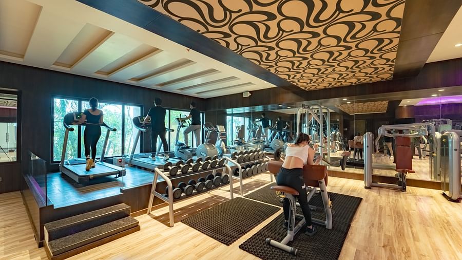Individuals exercising in the spacious gym at Crescent Spa & Resort, Indore