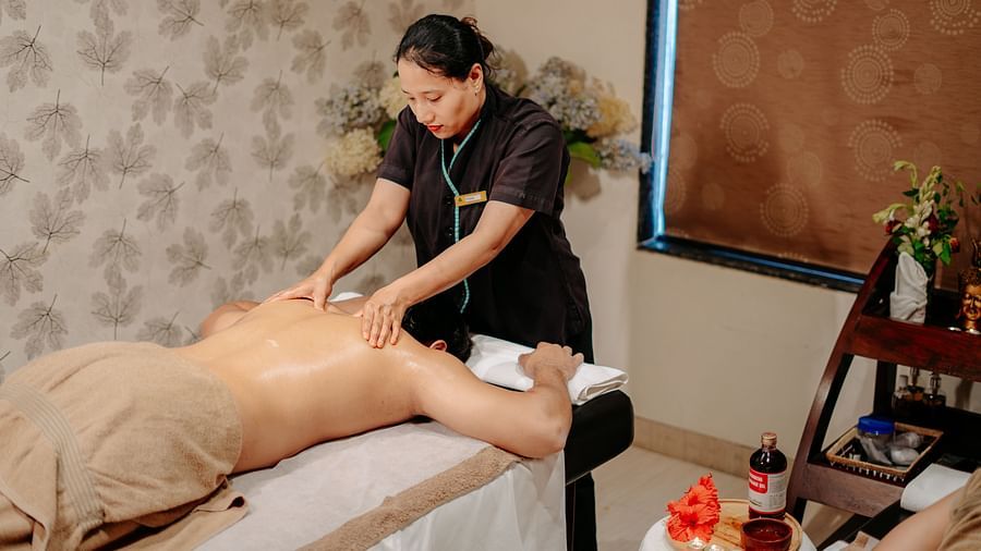 A woman providing a back and shoulder massage to a guest at Crescent Spa & Resort, Indore