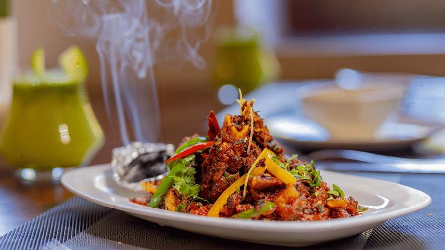 A close-up of a garnished appetizer dish on a plate at the restaurant in Estherea Bagh, Ranthambore.
