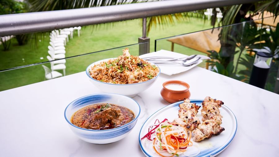 Plates of biryani, curry and salad served on a table at Grande Bay Resort & Spa.