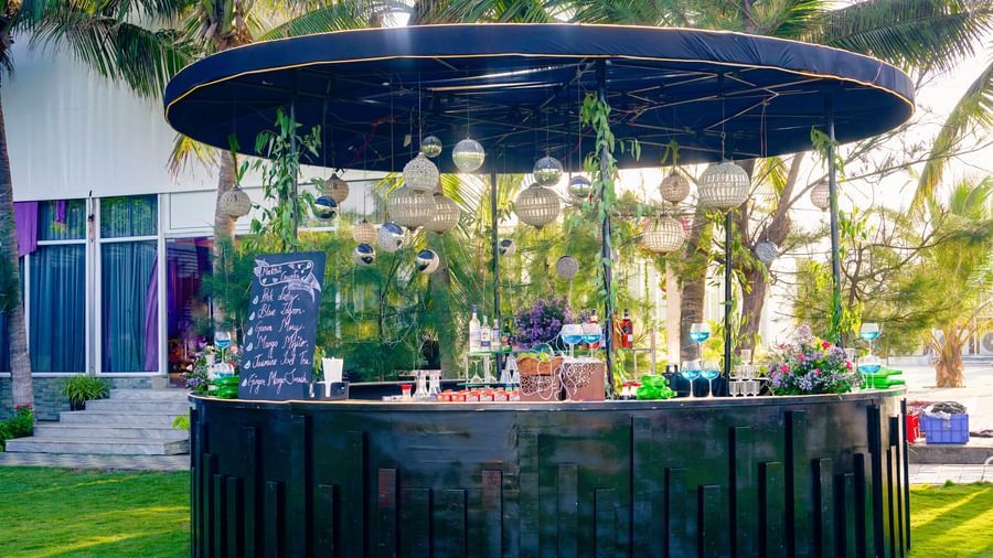 An outdoor bar decorated with flowers with green trees at the back at Grande Bay Resort & Spa.