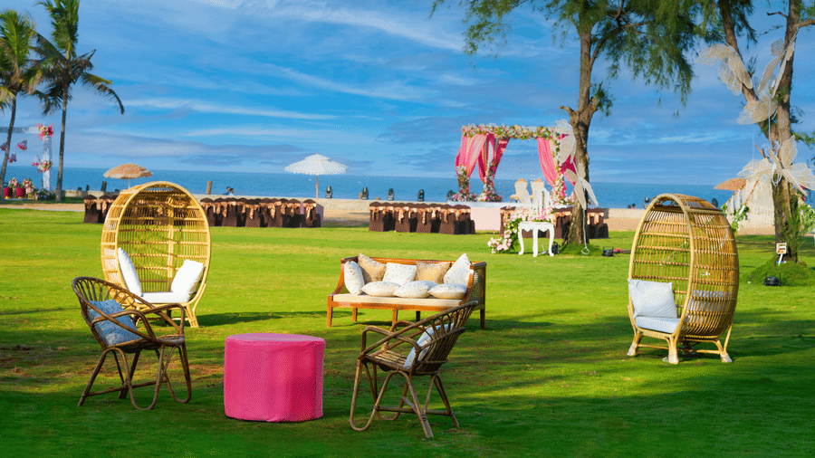 A cosy outdoor lounge seating arranged on the lawn overlooking a beachfront wedding mandap in Mahabalipuram - Grande Bay Resort & Spa, Mamallapuram
