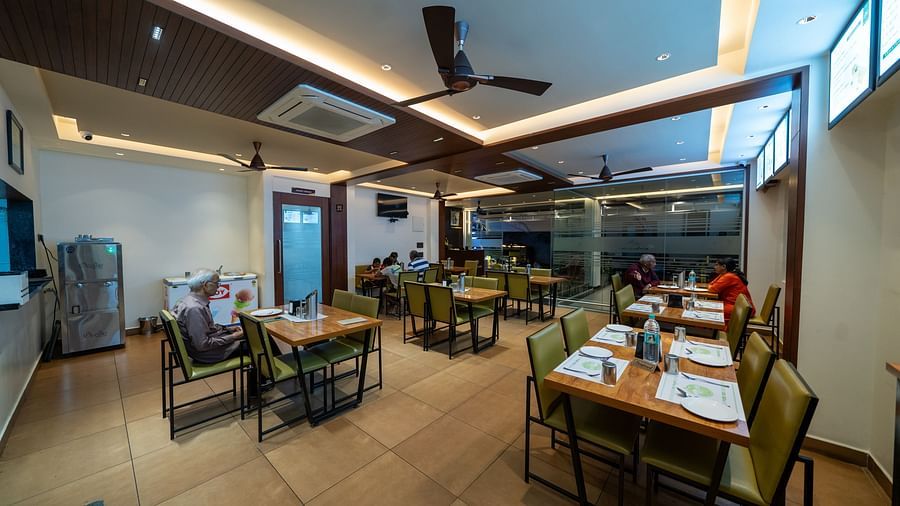 Full view of the dining area at Hari Govinda's, with all tables and chairs neatly set and bright lighting illuminating the space