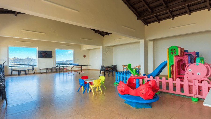 A colourful indoor play area for children featuring plastic slides and small chairs at Himalayas Resort By The Lake Hill, Mukteshwar.