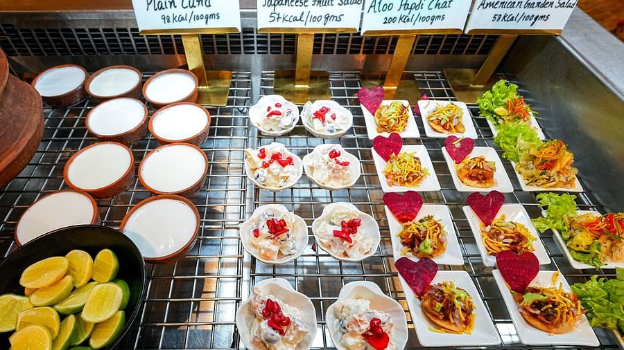 A vibrant selection of salads, starters, and dressings elegantly arranged on a buffet. - Tara, Comfort Hotel in Hyderabad - Ramoji Film City.