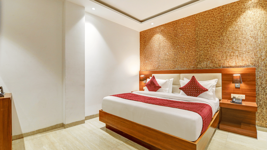 High-angle corner view of a bright hotel room highlighting the minimalist decor and wooden finishes - Hotel Velocity