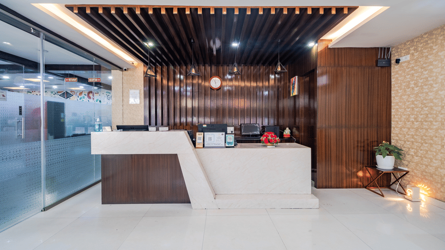 Reception front view with a wood-decorated ceiling and lights at Lemonridge by Monday Hotels - Kukatpally.