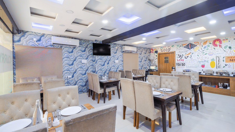 Dining tables arranged in the restaurant Curry Leaf at Lemonridge by Monday Hotels - Kukatpally.
