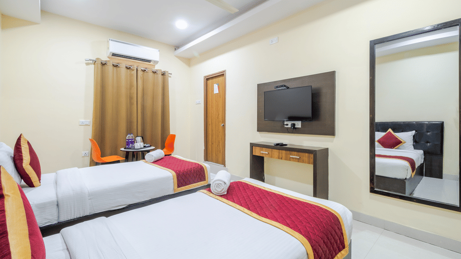 Comfort room featuring 2 cosy beds, mirror, wardrobe, and wall-mounted TV at Lemonridge by Monday Hotels - Kukatpally.