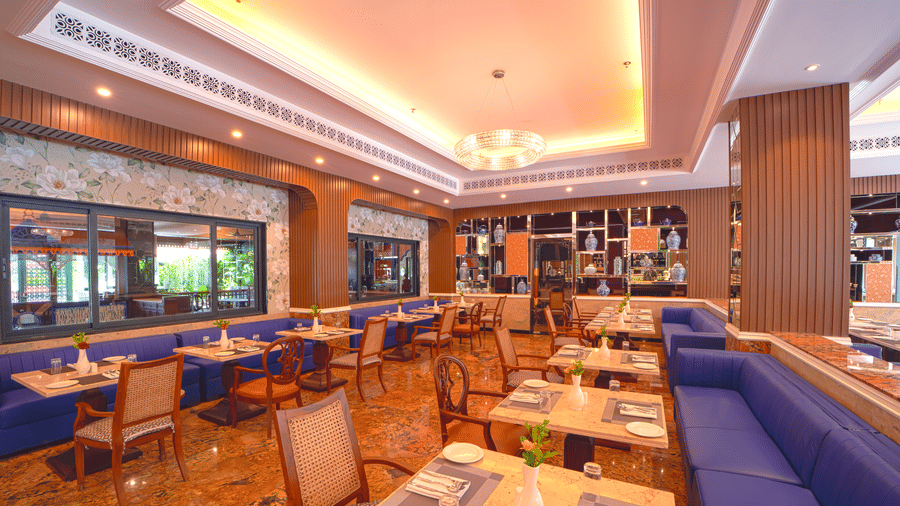 Modern restaurant interior with long, blue upholstered booths and matching chairs, set against a richly decorated wall Modern restaurant interior with long, blue upholstered booths and matching chairs, set against a richly decorated wall at MAYFAIR Bay Res