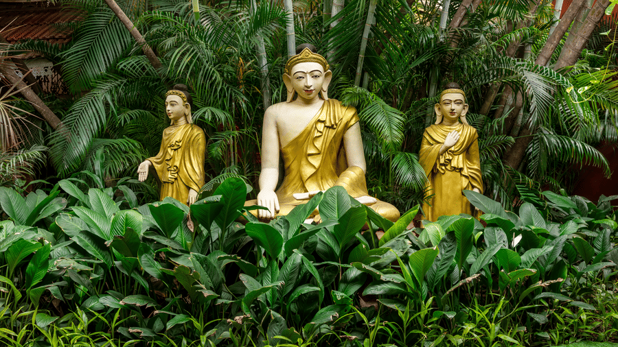 Golden Buddha statues surrounded by lush tropical garden at Mayfair Lagoon Bhubaneswar