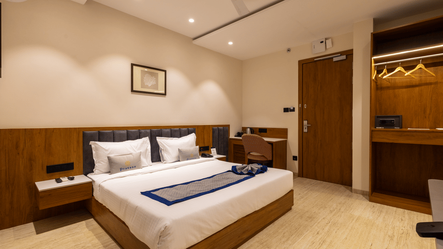 Modern bedroom with comfortable bed and open wardrobe at Pravasa Stay Bapat Square, Indore.