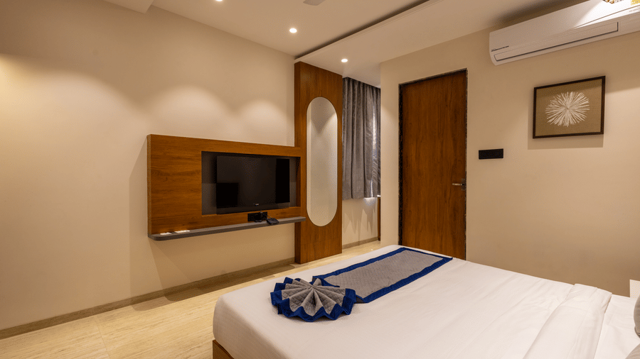 Room featuring wooden TV panel and comfortable double bed at Pravasa Stay Bapat Square, Indore.