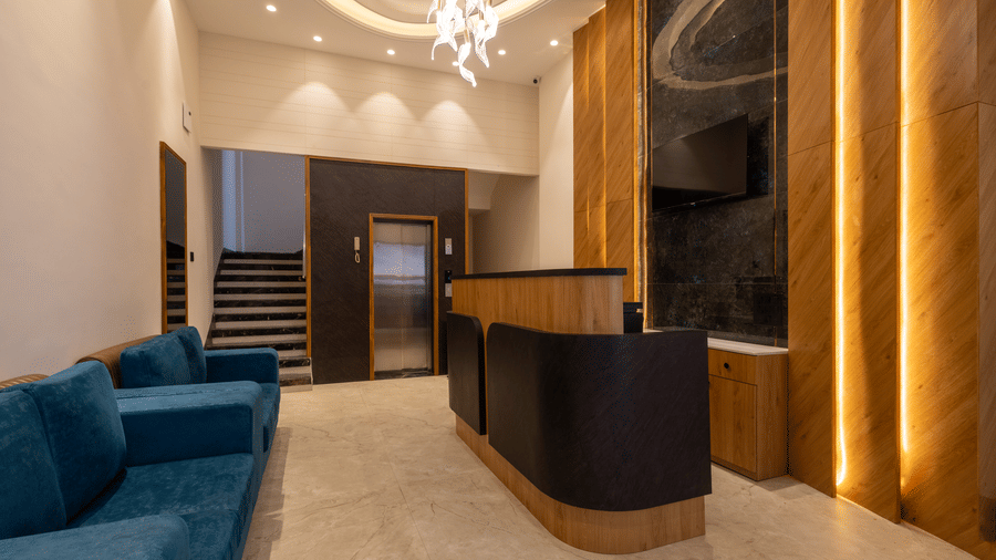 The sleek reception desk and lounge space at Pravasa Stay Bapat Square, Indore.