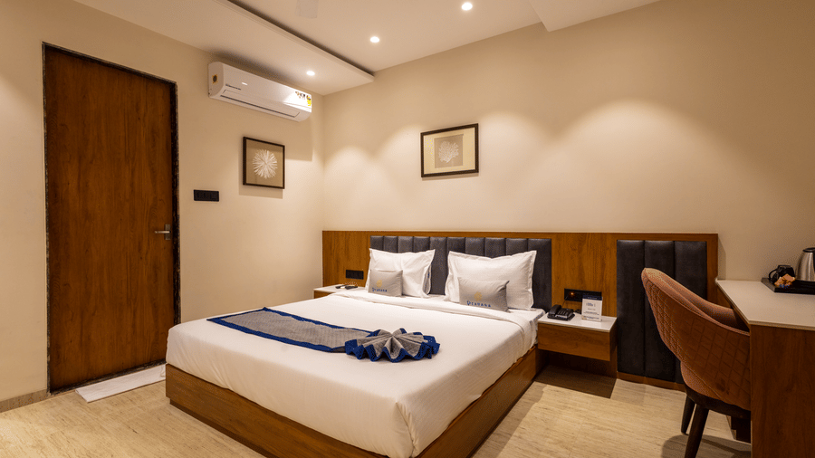 Deluxe room with queen bed and work desk at Pravasa Stay Bapat Square, Indore.