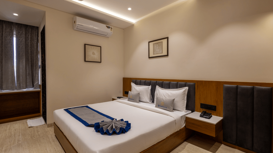 A side angle shot of king size bed in a room at Pravasa Stay Bapat Square.