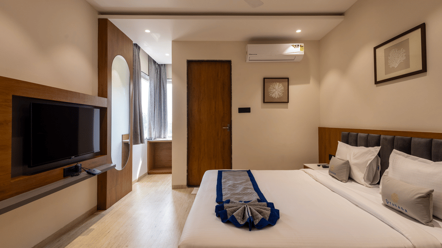 Well-appointed bedroom with plush bed and corridor access at Pravasa Stay Bapat Square, Indore.
