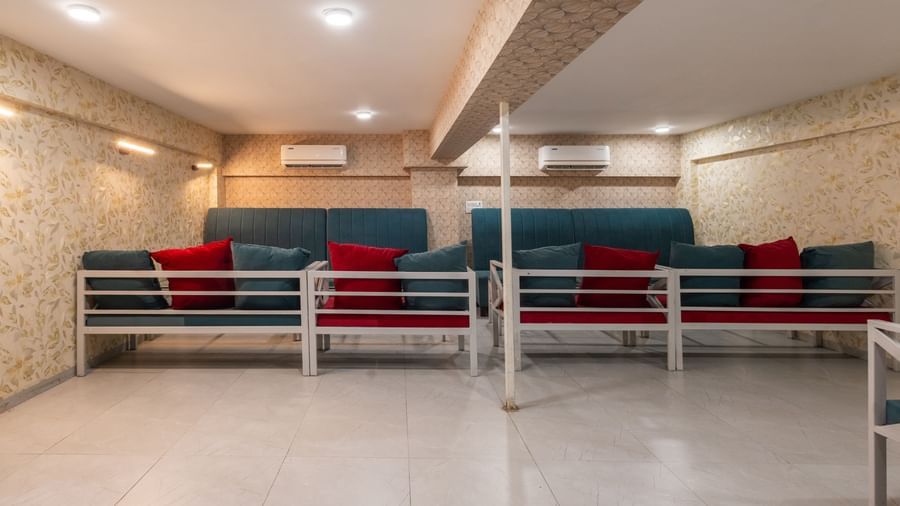 Indoor lounge with cushioned seating, metal railings, and soft lighting at Pravasa Stay Dewas Naka, Indore.