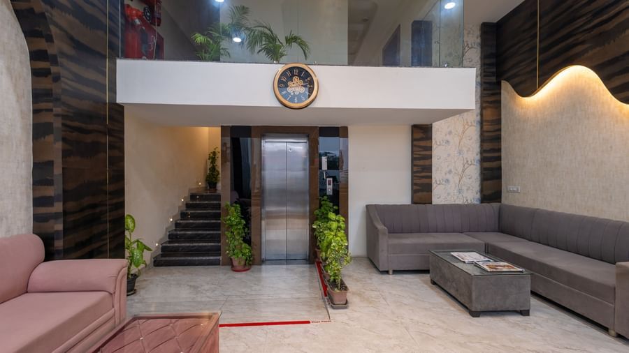 Lobby area with sofas, plants, and a lift at Pravasa Stay Dewas Naka, Indore.