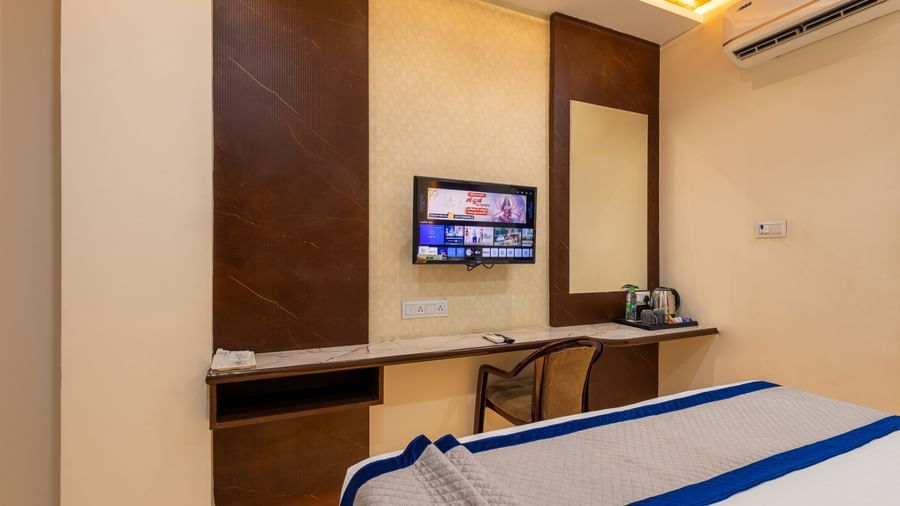 Room with double bed, TV, desk, and wall mirror at Pravasa Stay Dewas Naka, Indore.